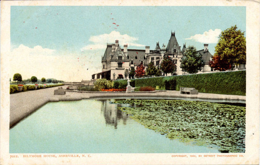 Hand tinted 1902 postcard of Biltmore House seen across a lily pond, with gardens and hedges in front